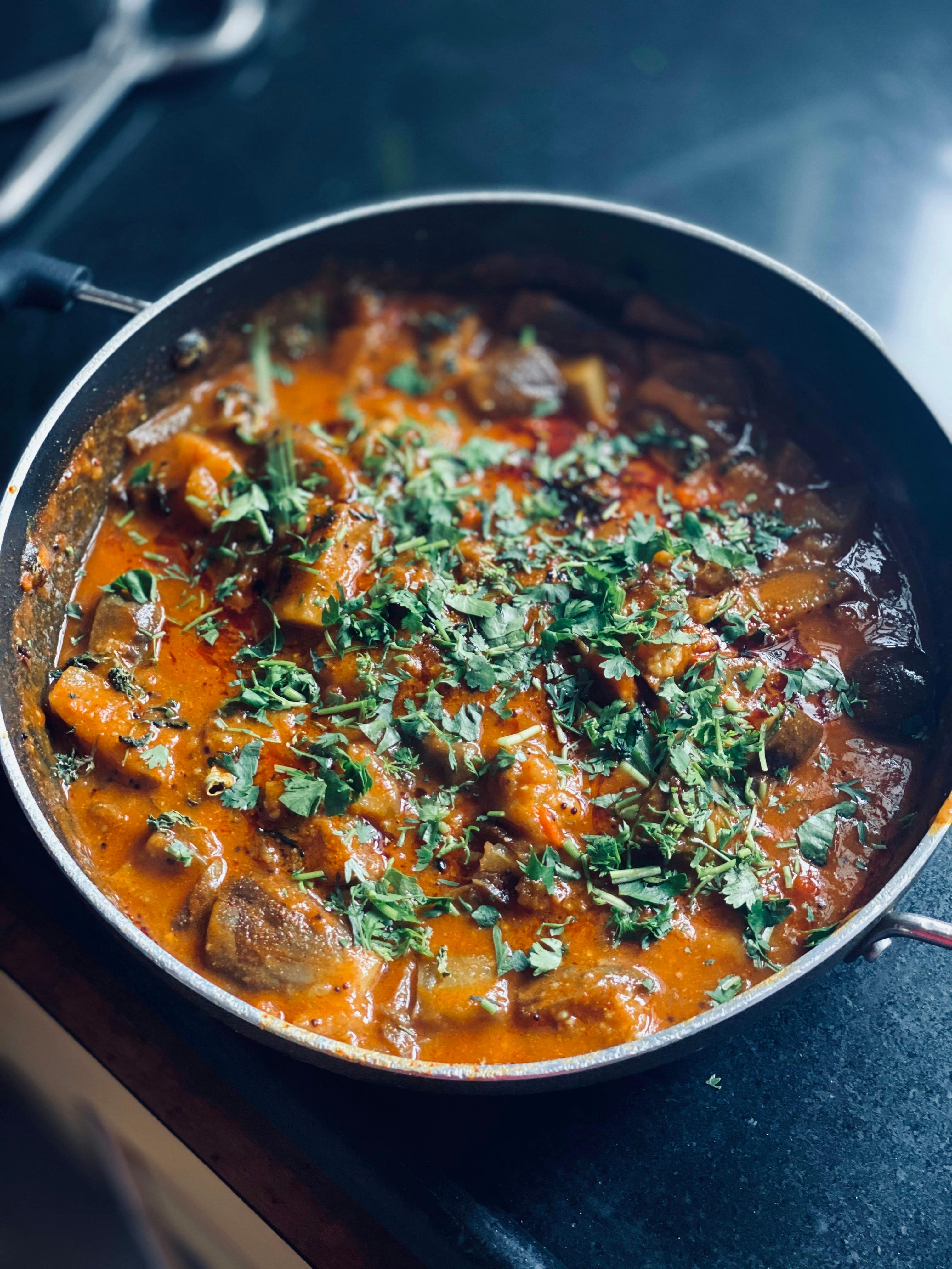A slow-cooked meat dish with deep gravy and fresh garnish